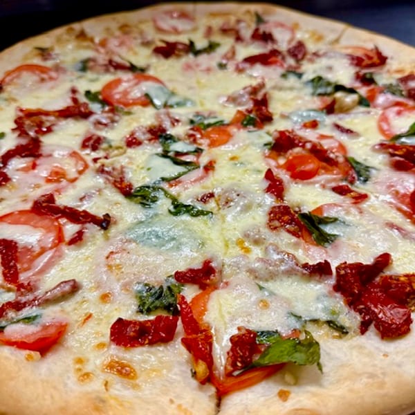 White pizza with fresh tomato, spinach and sun-dried tomato