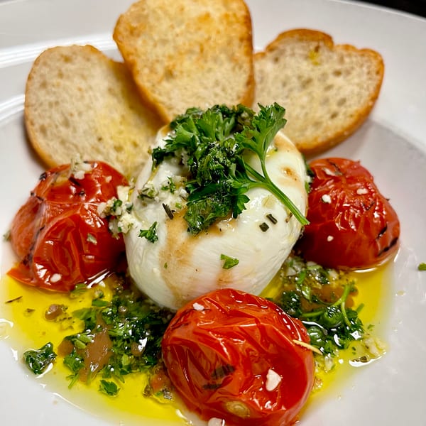 Creamy burrata, roasted tomatoes, fresh herbs, and olive oil served with toasted bread.